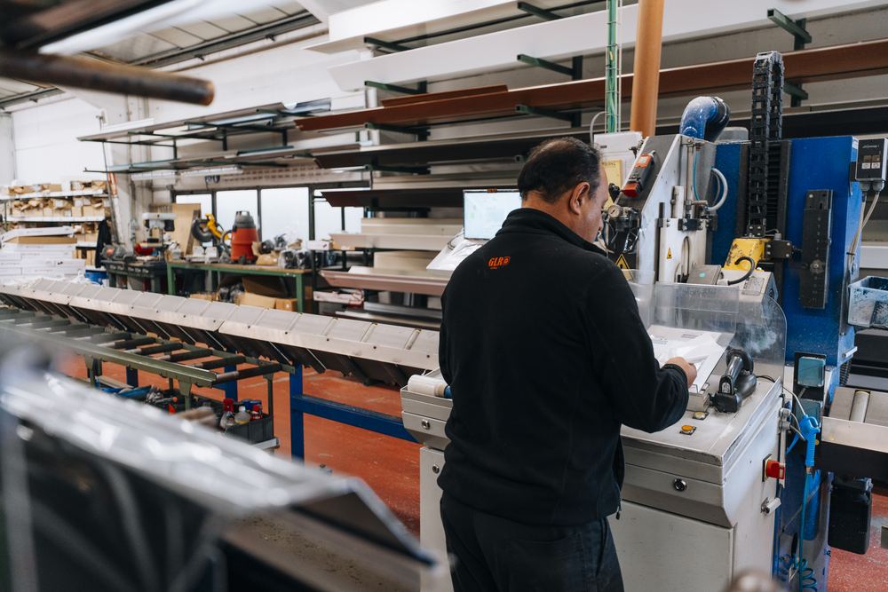 Medewerker bedient een machine in de rolluikproductie